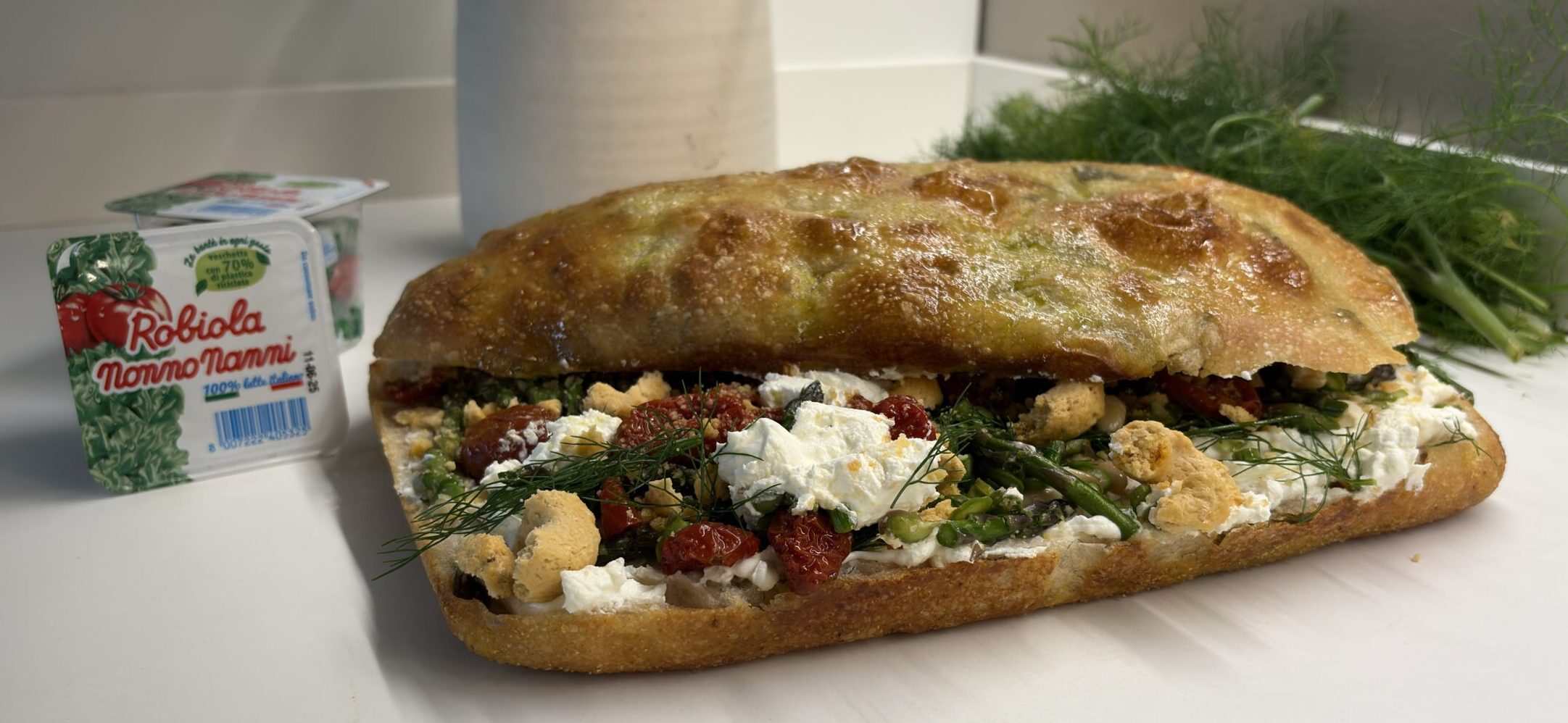 Focaccia alle erbe con robiola Nonno Nanni, asparagi selvatici, un battuto di pomodorini, pinoli, finocchietto e tarallo sbriciolato